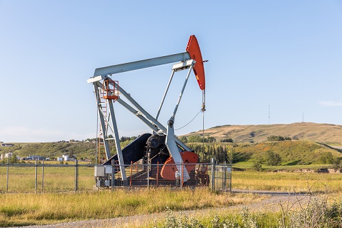 An image of an oil derrick in an Alberta field.